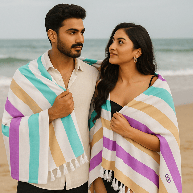 Couple at the beach wrapped in colorful striped beach towels.